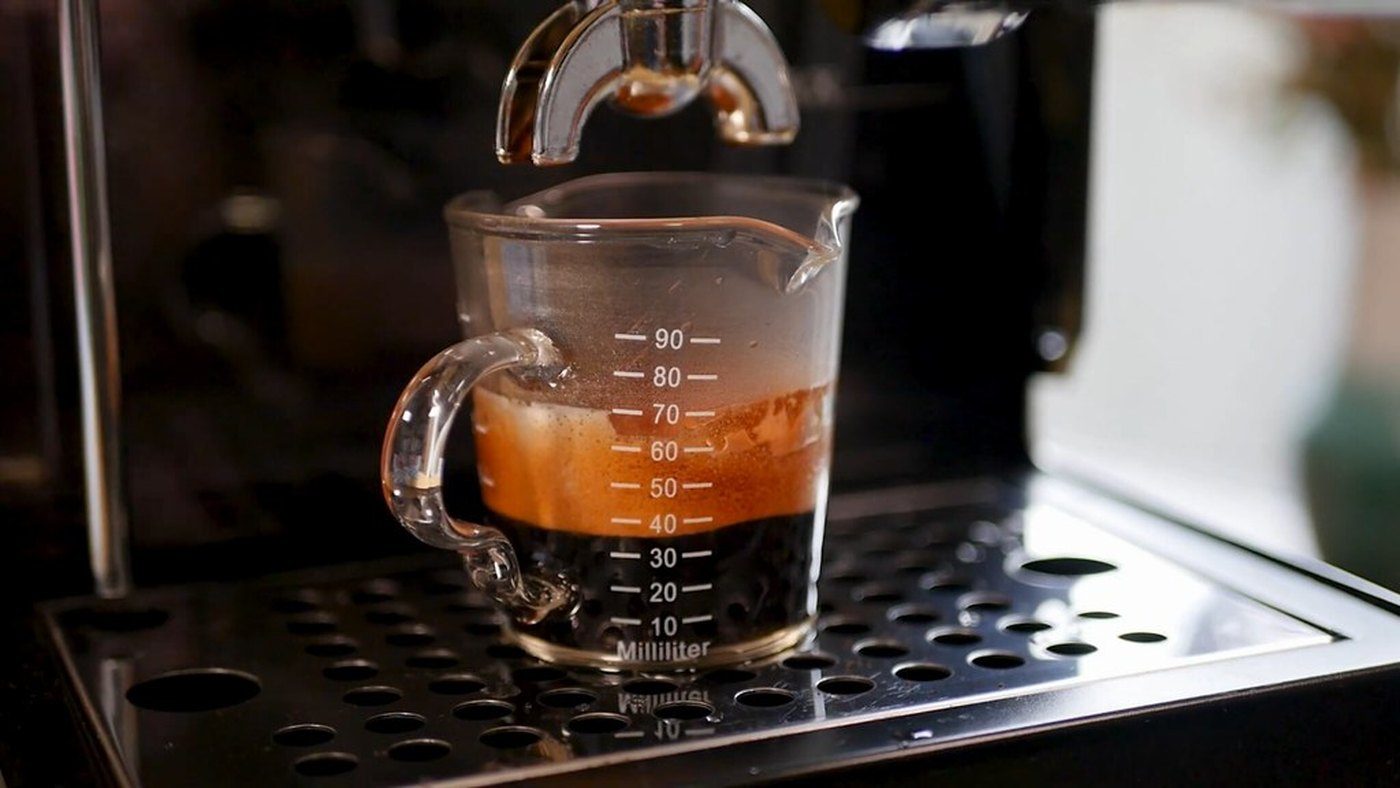 White cup used to check black flakes from a Gaggia Classic Pro steam wand