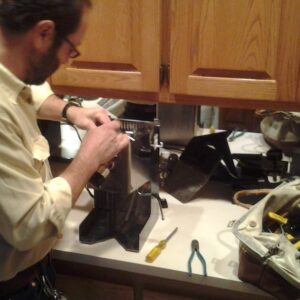 Owner servicing a Gaggia Classic machine on a kitchen counter
