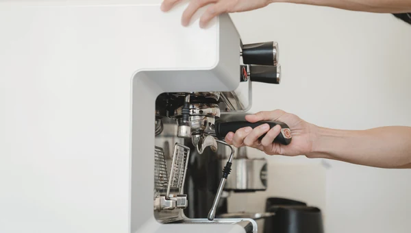 Hands operating a home espresso machine