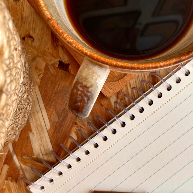 Coffee notebook and pen on a wooden table