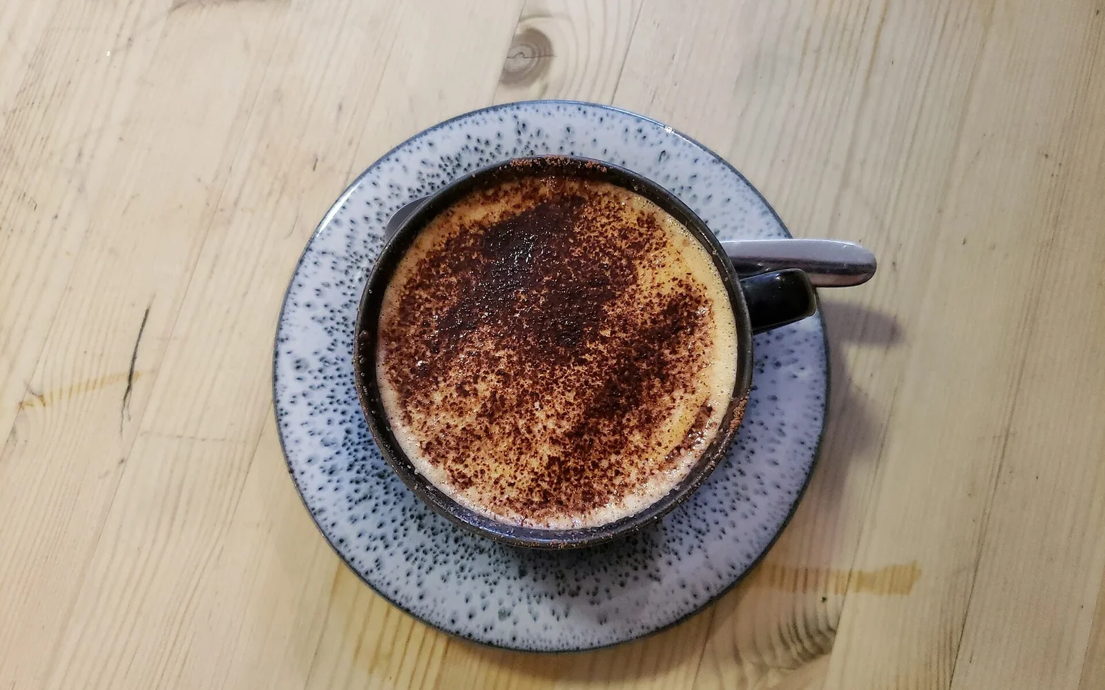 Small ceramic cup of cappuccino with a deeper foam layer