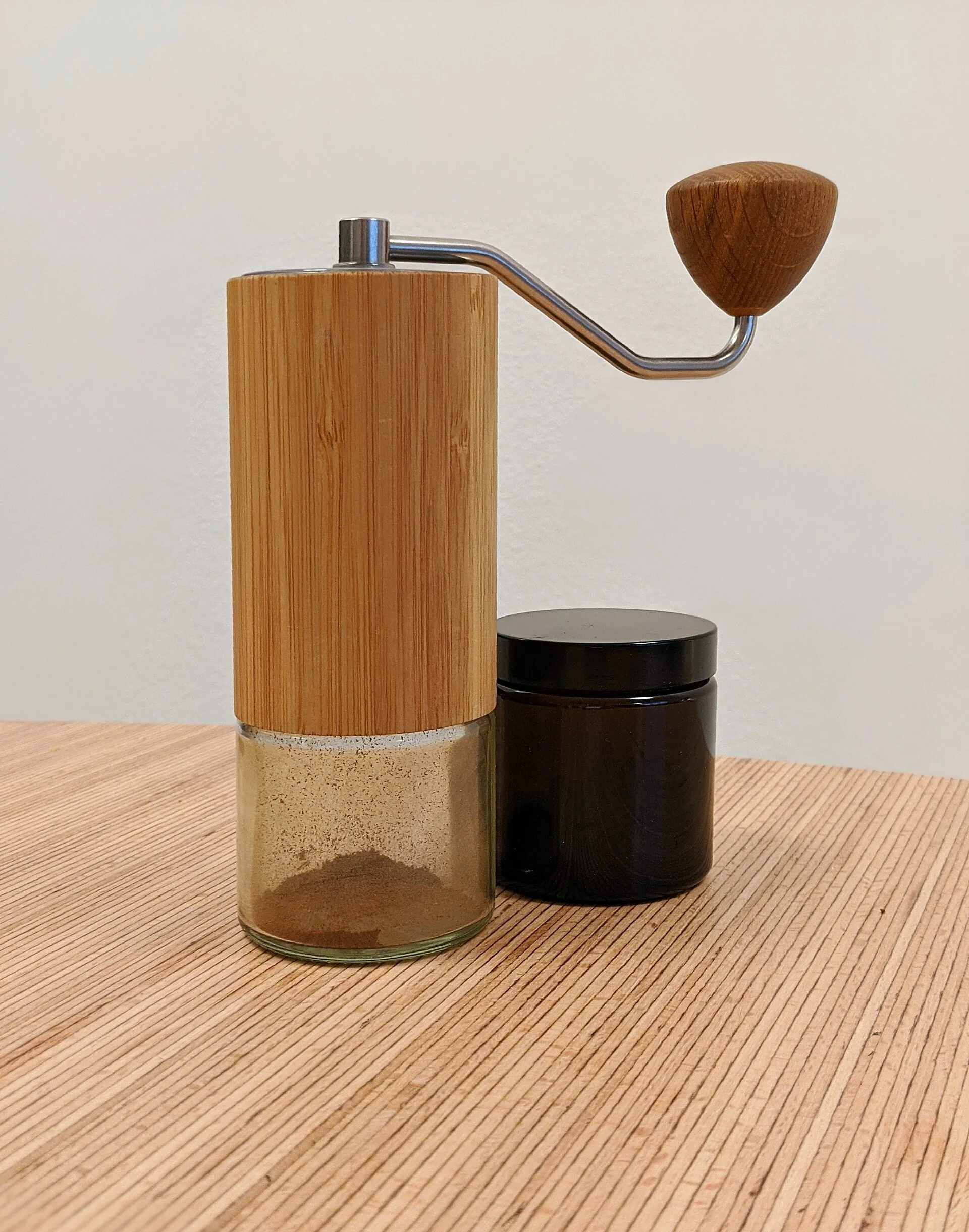 Comandante hand grinder with catch cup beside it