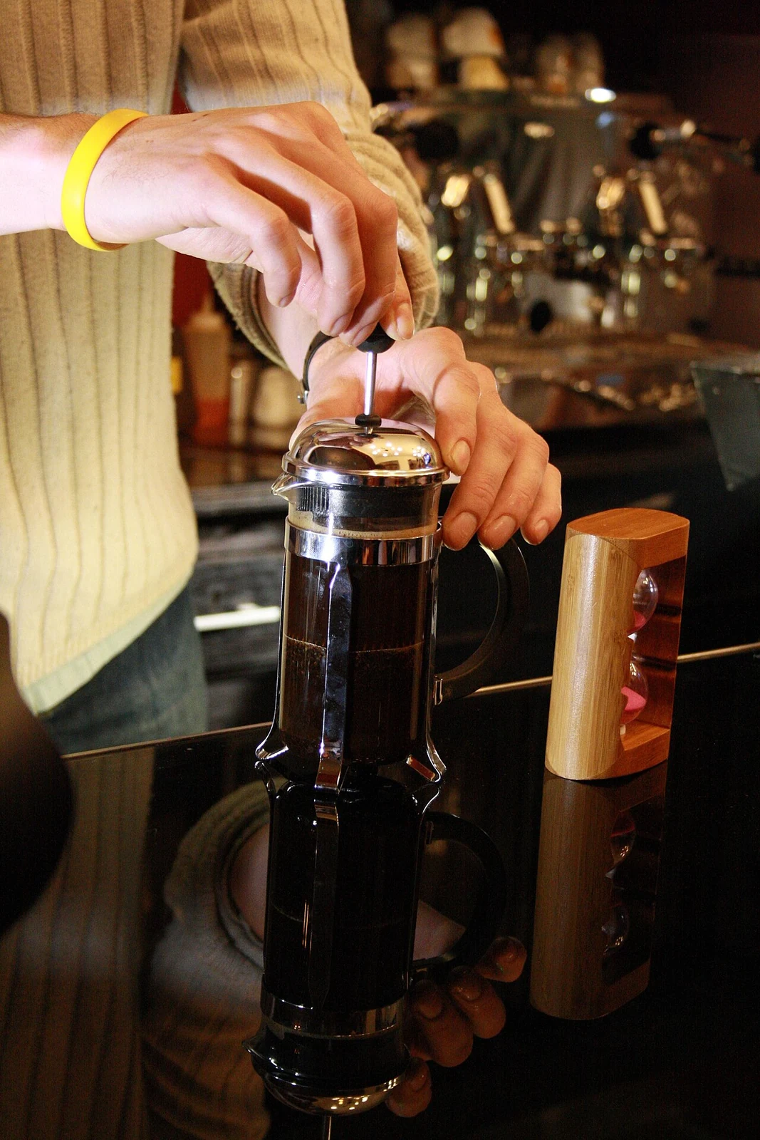 Barista pressing the plunger on a glass French press