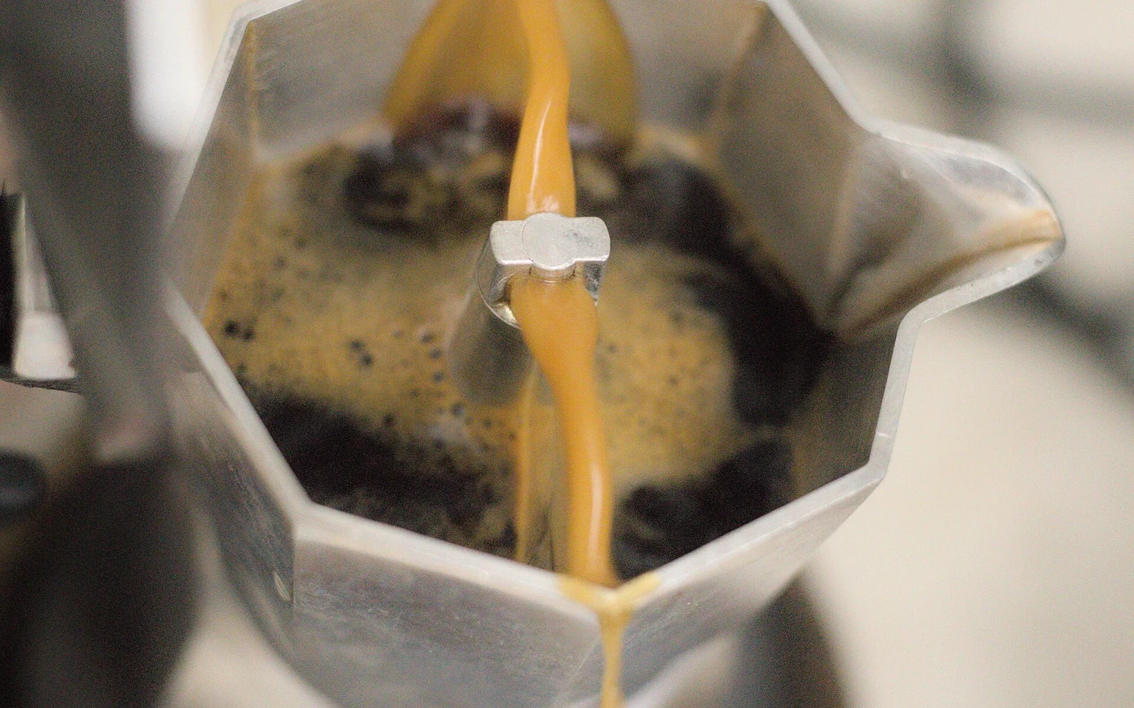Coffee flowing into the upper chamber of an open moka pot