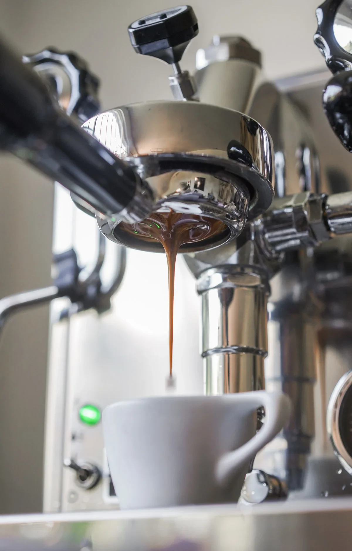Espresso flows from a bottomless portafilter on a different espresso machine