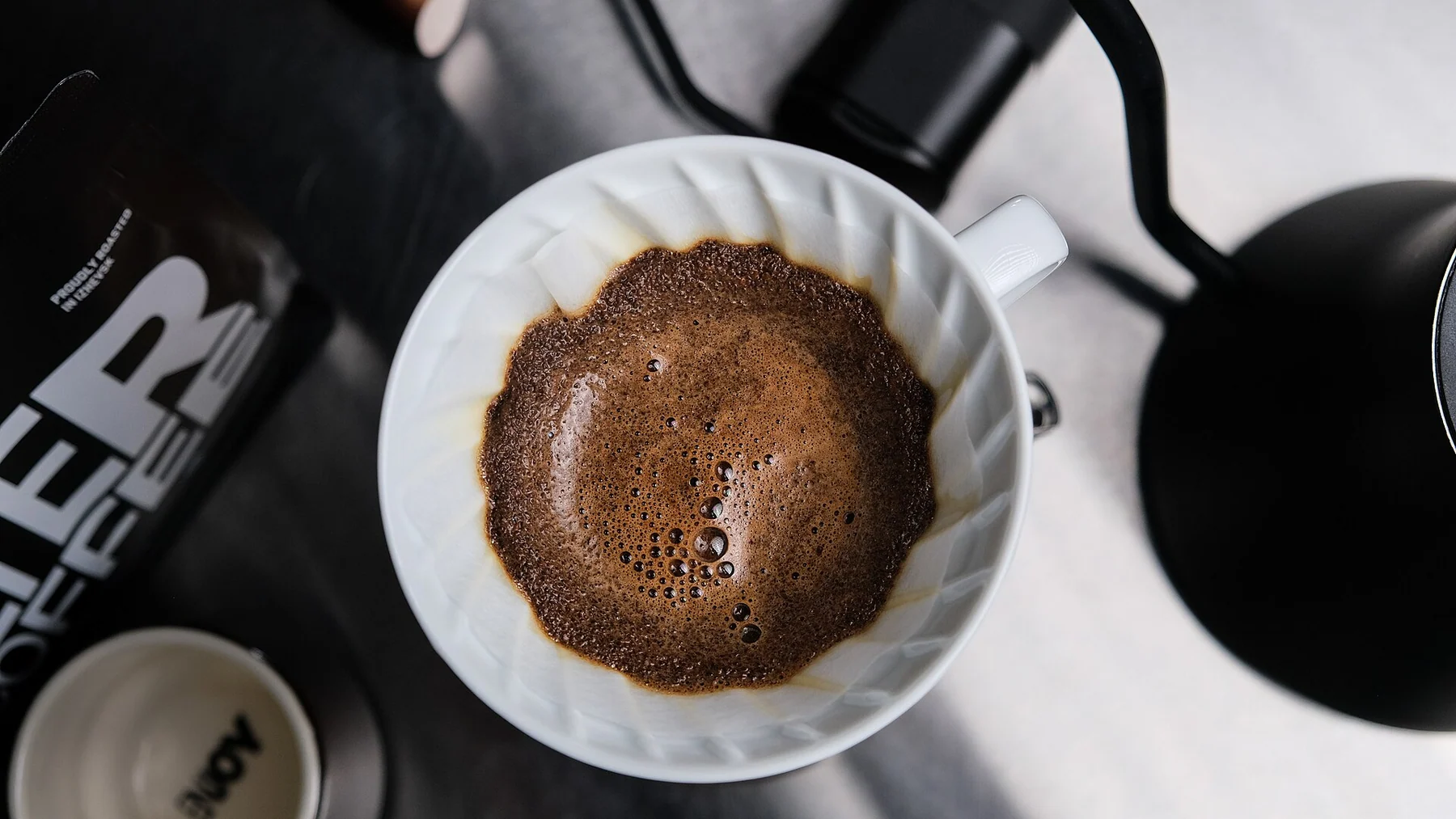 Wet V60 paper filter holding coffee during a pour-over brew